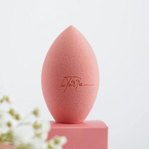 Aesthetic photo of a pink makeup sponge among delicate white flowers, perfect for beauty concepts.