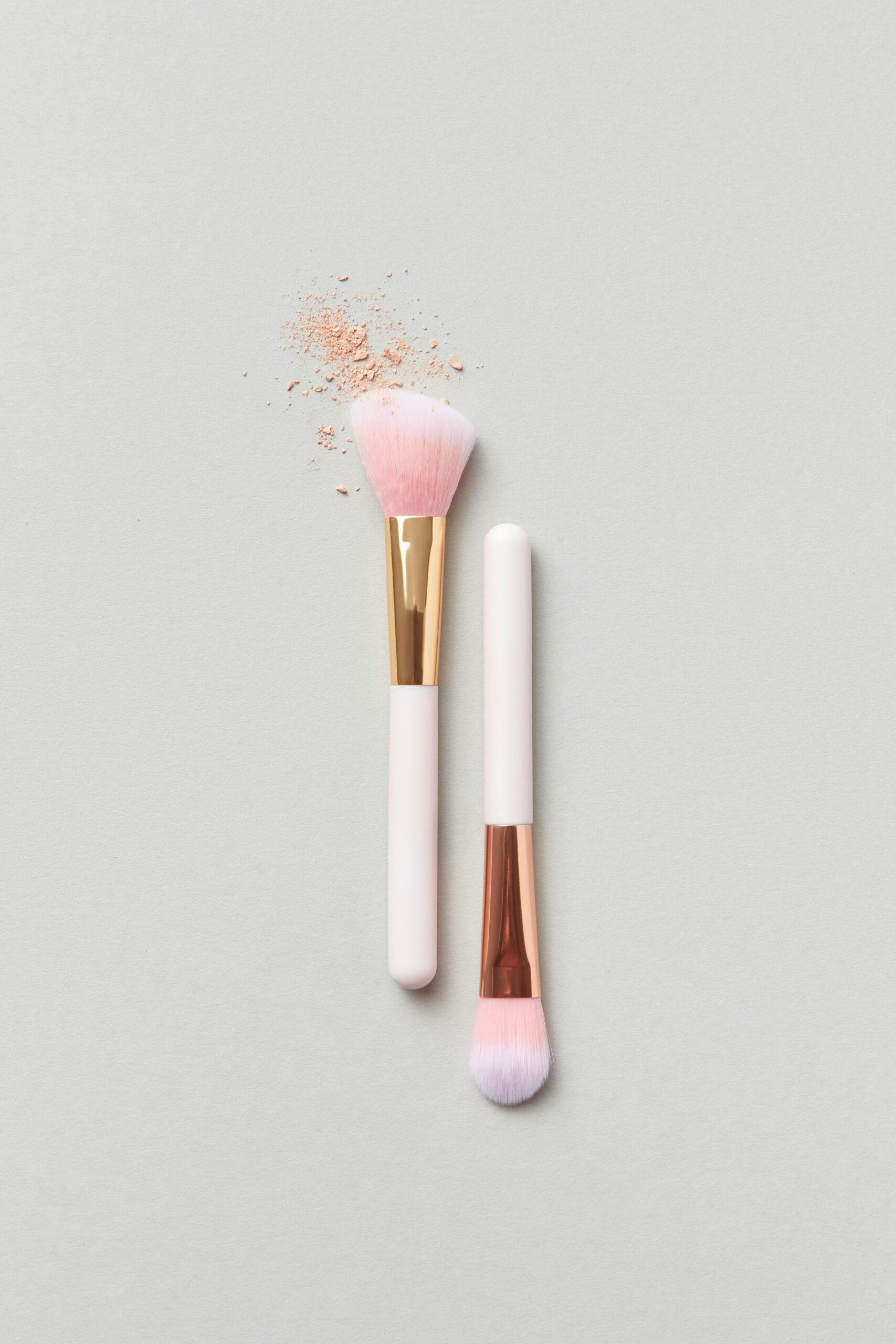 Elegant makeup brushes with blush powder in a minimalist flat lay design.